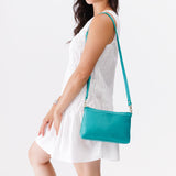 Seafoam Small | Model holding a zip top crossbody bag with detachable strap