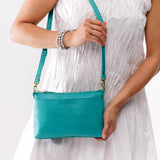 Seafoam Small | Model holding a zip top crossbody bag with detachable strap