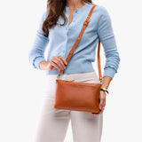 Sienna Small | Model holding a zip top crossbody bag with detachable strap