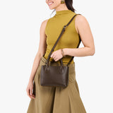 Grizzly Small | Model holding petite tote purse with structured leather handles and crossbody strap
