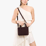Velvet Brown Small | Model holding petite tote purse with structured leather handles and crossbody strap