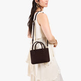 Velvet Brown Small | Model wearing petite tote purse with structured leather handles and crossbody strap