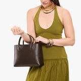 Grizzly Large | Model holding mid-size tote purse with  structured leather handles and crossbody strap