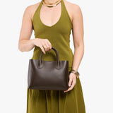 Grizzly Large | Model holding mid-size tote purse with  structured leather handles and crossbody strap