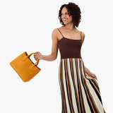 Sunshine Large | Model wearing a mid-size tote purse with  structured leather handles and crossbody strap