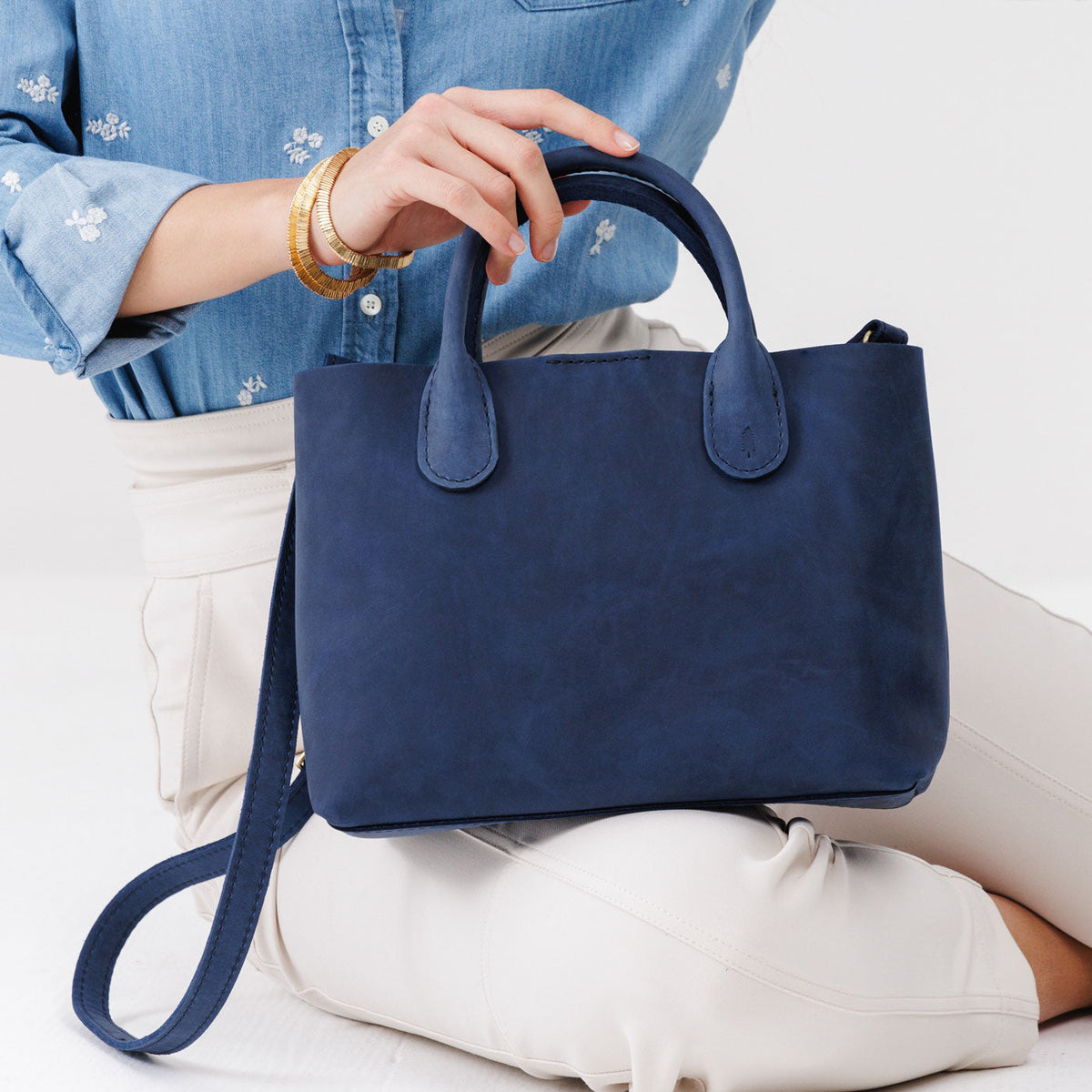 Deep Water*Large | Model holding mid-size tote purse with  structured leather handles and crossbody strap