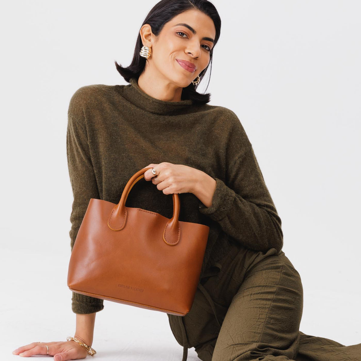 Honey*Large | Model holding mid-size tote purse with  structured leather handles and crossbody strap