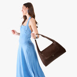 Coldbrew Large | A model holding a slouchy triangle shaped shoulder bag with a flap