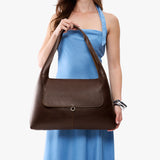 Coldbrew Large | A model holding a slouchy triangle shaped shoulder bag with a flap
