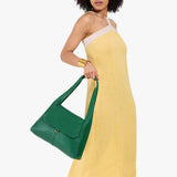 Bacalar Medium | A model holding a slouchy triangle shaped shoulder bag with a flap