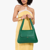Bacalar Medium | A model holding a slouchy triangle shaped shoulder bag with a flap