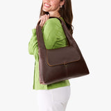Coldbrew Medium | A model holding a slouchy triangle shaped shoulder bag with a flap