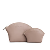 Stone | Comparison shot of small and large seashell shaped leather makeup bags with curved top zipper and flat bottom
