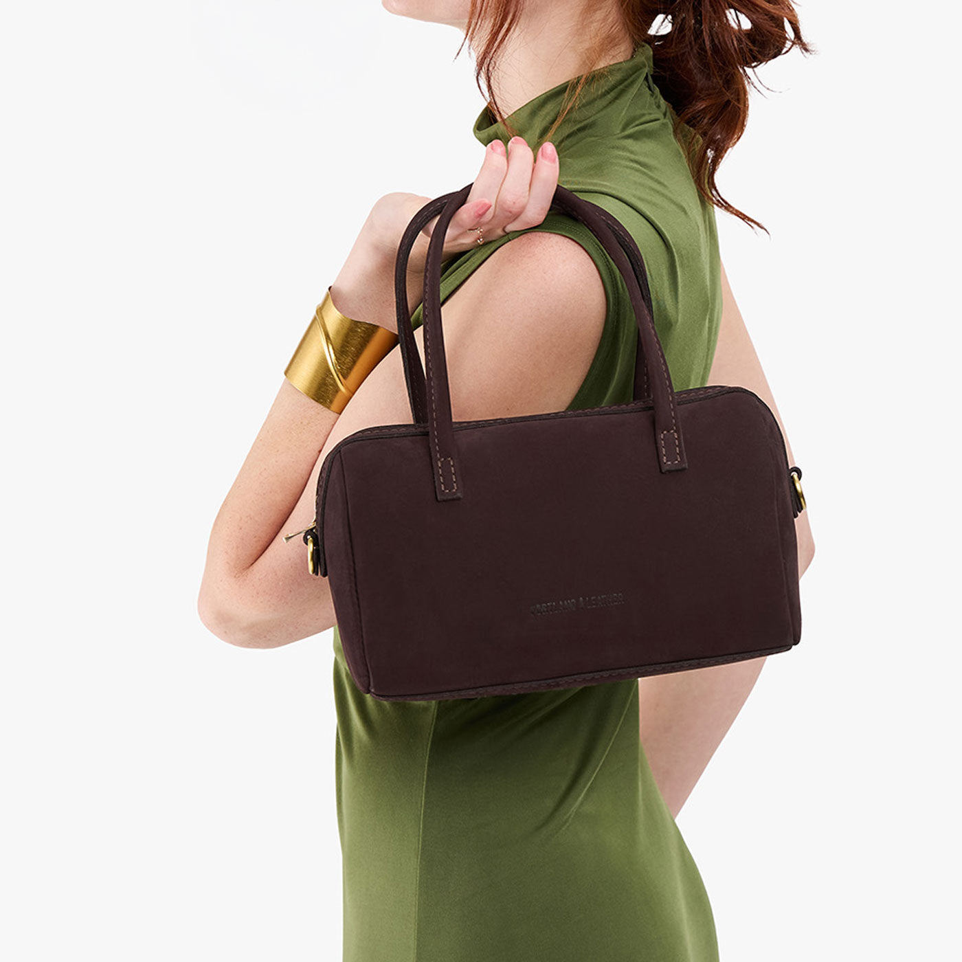Velvet Brown*Large | Model holding mini duffle shaped handbag with crossbody strap