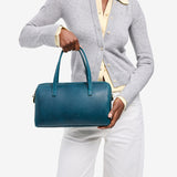 Westward Blue Oversized | Model holding mini duffle shaped handbag with crossbody strap