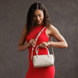 Bone Small | Model wearing mini duffle shaped handbag with crossbody strap
