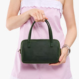 Evergreen Small | Model holding mini duffle shaped handbag with crossbody strap