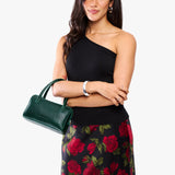 Forest Green Small | Model holding mini duffle shaped handbag with crossbody strap