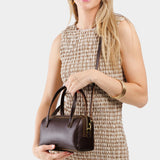 Grizzly Small | Model wearing mini duffle shaped handbag with crossbody strap