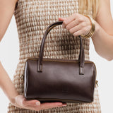 Grizzly Small | Model wearing mini duffle shaped handbag with crossbody strap