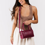 Orchid Small | Model wearing mini duffle shaped handbag with crossbody strap