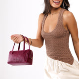 Orchid Small | Model wearing mini duffle shaped handbag with crossbody strap