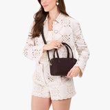 Velvet Brown Small | Model holding mini duffle shaped handbag with crossbody strap
