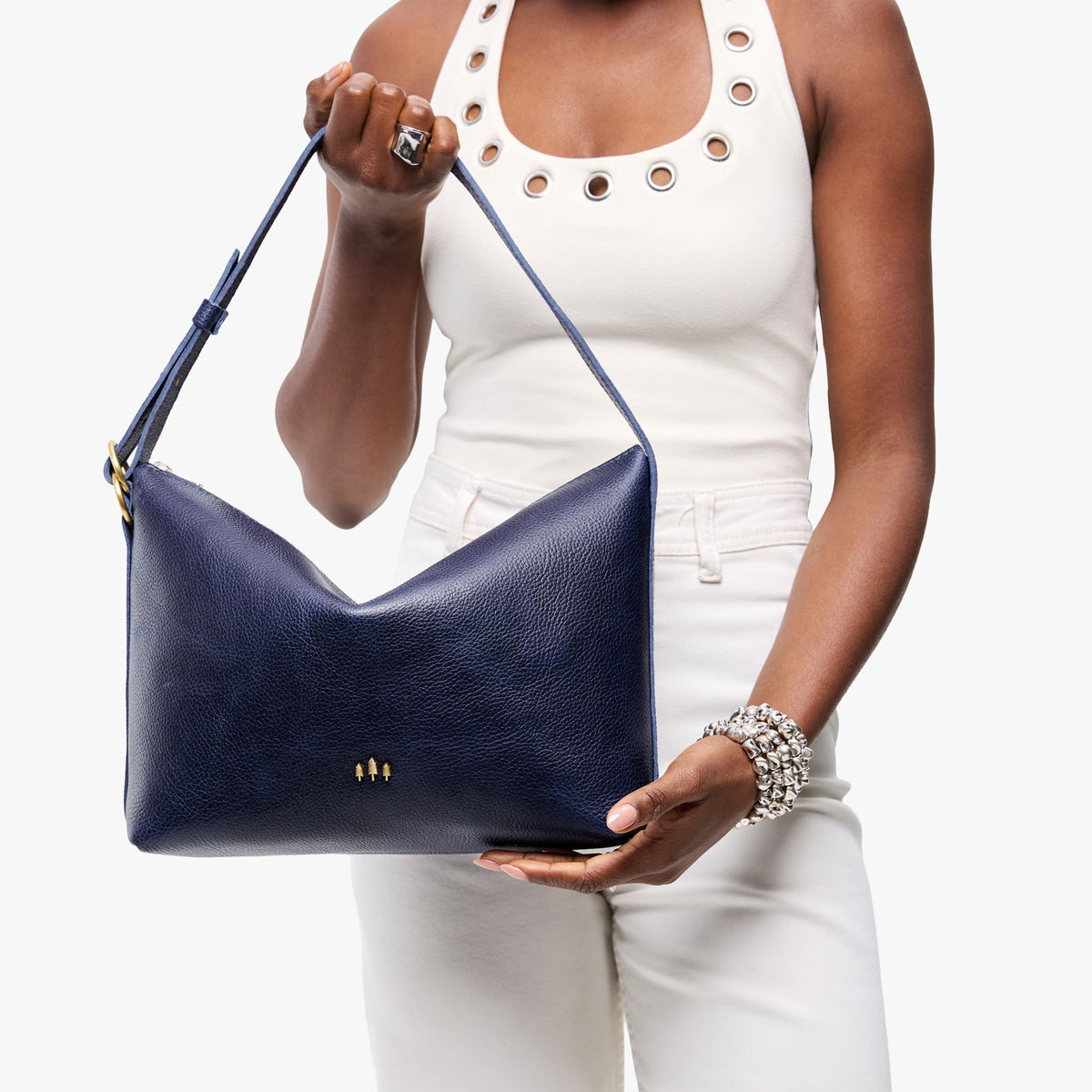 Cobalt*Large | Model Wearing medium sized slouchy leather shoulder bag with zipper opening and three metal tree emblems