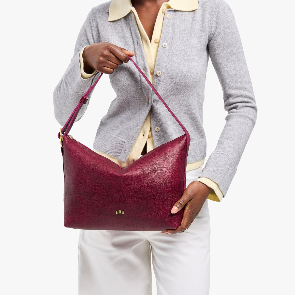 Orchid*Large | Model Wearing medium sized slouchy leather shoulder bag with zipper opening and three metal tree emblems