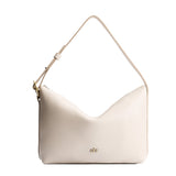 Pebbled Bone Large | Model Wearing medium sized slouchy leather shoulder bag with zipper opening and three metal tree emblems