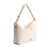 Pebbled Bone Large | Model Wearing medium sized slouchy leather shoulder bag with zipper opening and three metal tree emblems