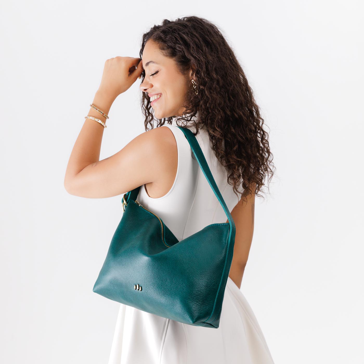 Sea Glass*Large | Model wearing medium sized slouchy leather shoulder bag with zipper opening and three metal tree emblems