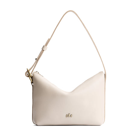 Pebbled Bone*Large | Model Wearing medium sized slouchy leather shoulder bag with zipper opening and three metal tree emblems
