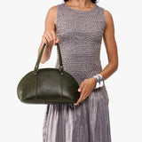 Pebbled Olive Small | Model holding a half circle crossbody bag with handles and removable crossbody strap 