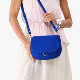 Blue Joy Small | Model wearing a petite leather Crossbody with a flap and magnetic closure