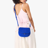 Blue Joy Small | Model wearing a petite leather Crossbody with a flap and magnetic closure