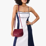 Orchid Small | Model wearing a petite leather Crossbody with a flap and magnetic closure