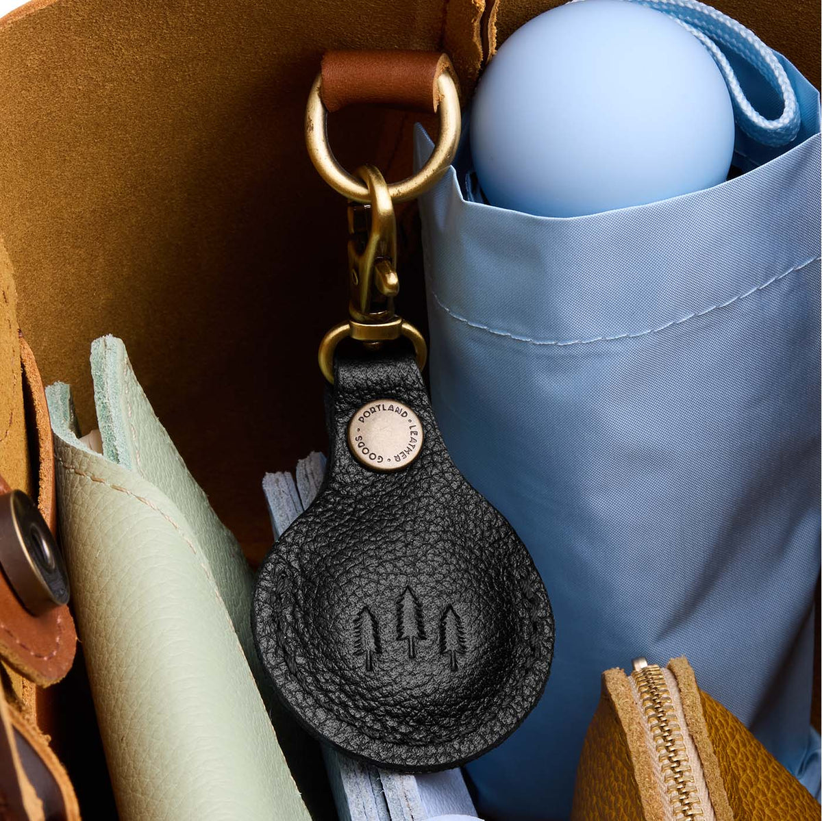 Pebbled--black | Round leather AirTag holder with snap closure and swivel lobster claw clasp