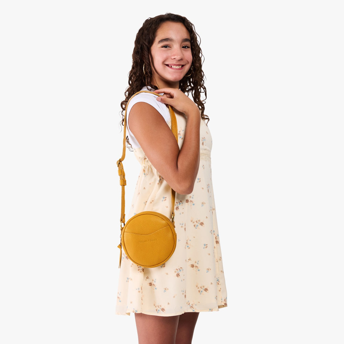 Sunshine | Model wearing a circle shaped crossbody bag with top zipper and gold accents