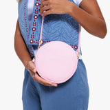 Pinkaboo | Model wearing a circle shaped crossbody bag with top zipper and gold accents