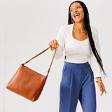 Honey Small | Model carrying triangular shoulder bag with antiqued brass finished hardware