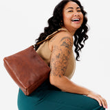 Nutmeg Small | Model carrying triangular shoulder bag with antiqued brass finished hardware