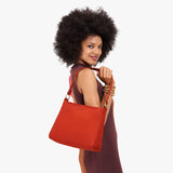 Paprika Small | Model holding a triangular shoulder bag with antiqued brass finished 