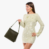 Pebbled Olive Small | Model holding a triangular shoulder bag with antiqued brass finished 