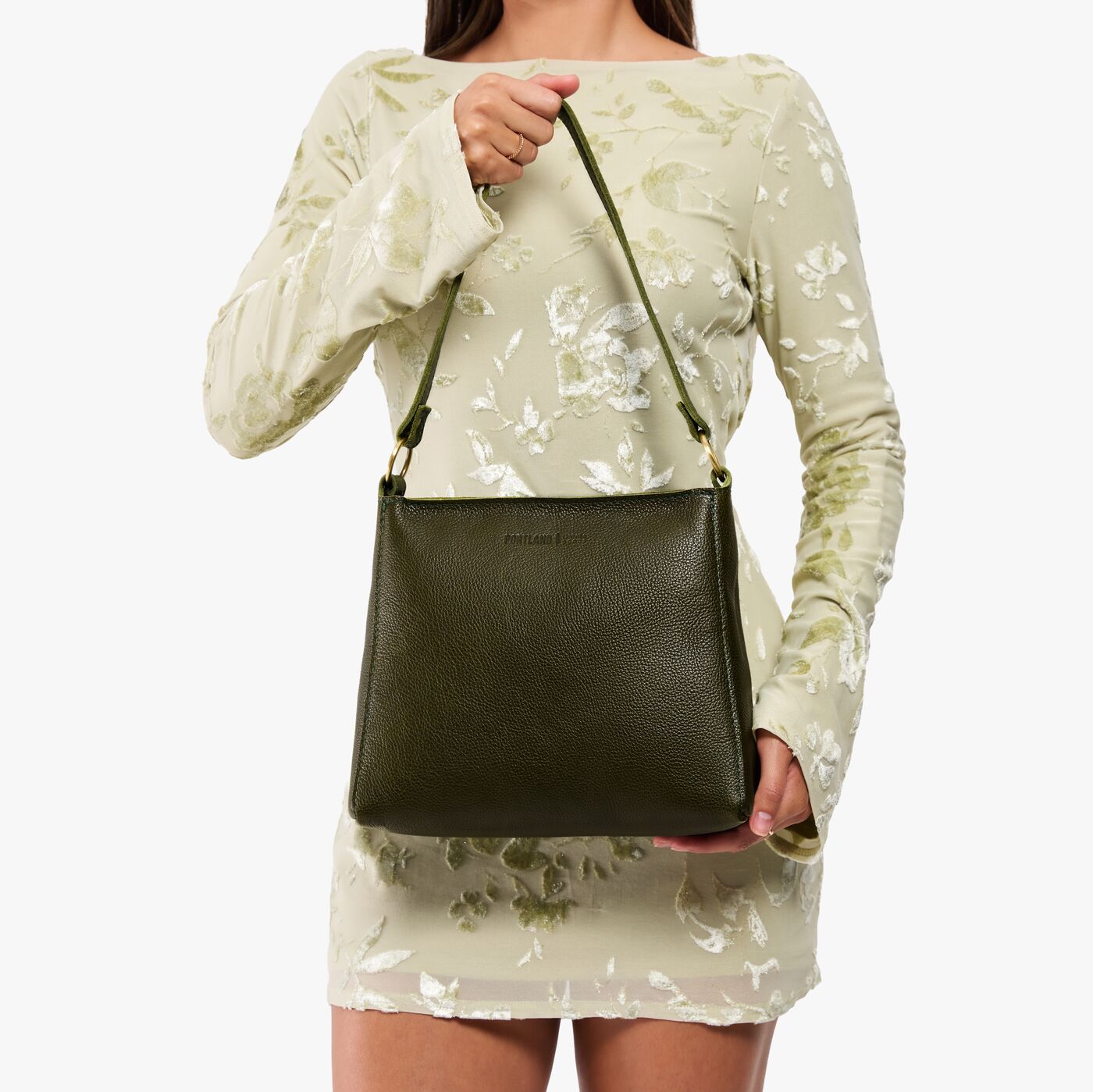 Pebbled Olive*Small | Model holding a triangular shoulder bag with antiqued brass finished 