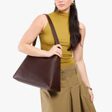 Coldbrew Large | Model carrying large triangular shoulder bag with antiqued brass finished hardware