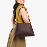 Coldbrew Large | Model carrying large triangular shoulder bag with antiqued brass finished hardware