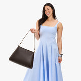 Grizzly Large | Model holding large triangular shoulder bag with antiqued brass finished hardware