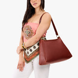 Nutmeg Large | Model carrying large triangular shoulder bag with antiqued brass finished hardware