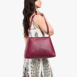 Orchid Large | Model carrying large triangular shoulder bag with antiqued brass finished hardware